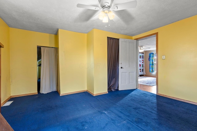 unfurnished bedroom featuring dark colored carpet, ceiling fan, and a textured ceiling