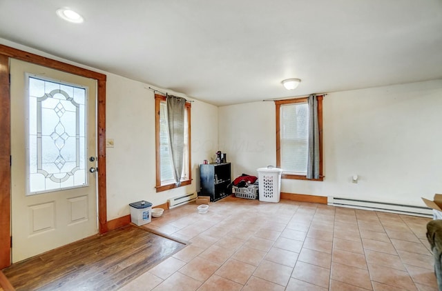 foyer entrance with light wood-type flooring and a baseboard radiator