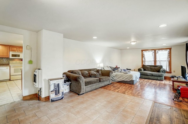 living room with heating unit and light hardwood / wood-style flooring