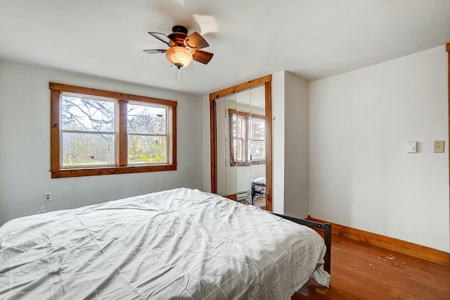 bedroom with ceiling fan, wood-type flooring, and a closet