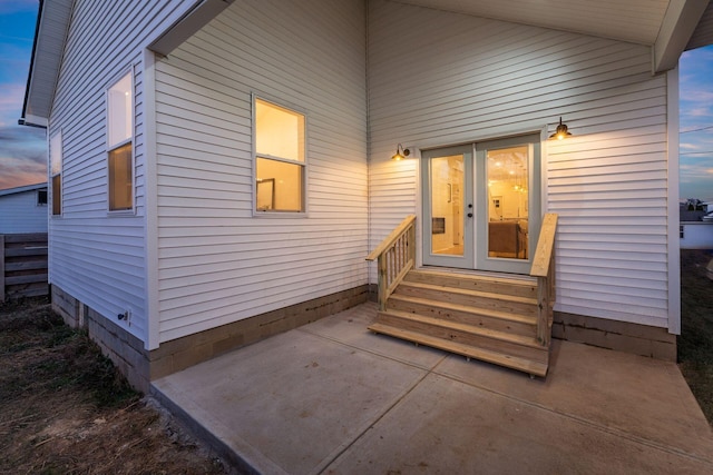 exterior entry at dusk with a patio area and french doors