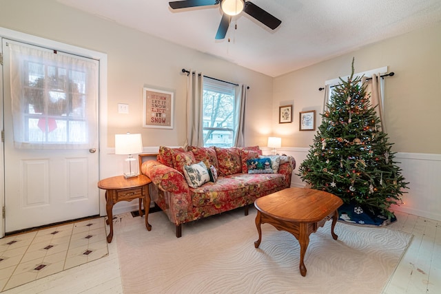 living room featuring a textured ceiling, light hardwood / wood-style floors, and ceiling fan