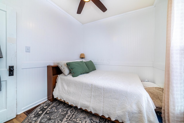 bedroom featuring hardwood / wood-style flooring, ceiling fan, and ornamental molding