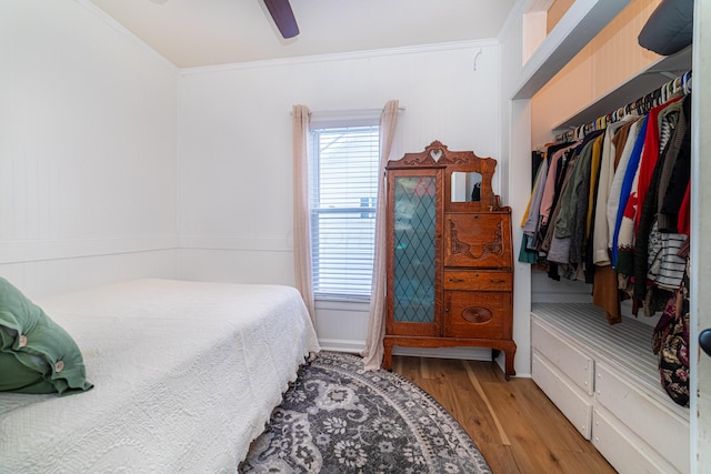 bedroom with ceiling fan, ornamental molding, light hardwood / wood-style flooring, and a closet