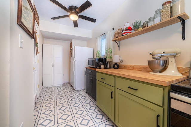 kitchen featuring ceiling fan, green cabinets, white refrigerator, and wooden counters