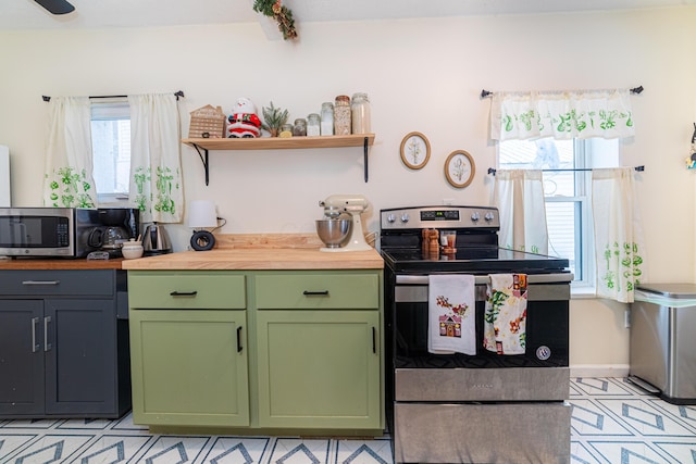 kitchen with baseboards, open shelves, stainless steel appliances, wood counters, and green cabinets