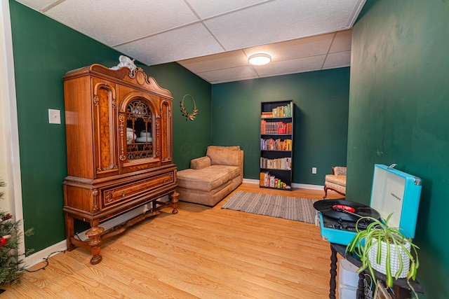 sitting room featuring a paneled ceiling and light wood-type flooring