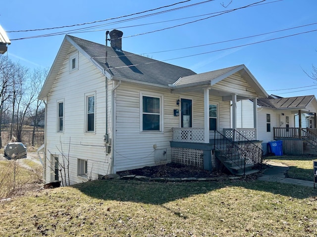 bungalow featuring a front lawn, a porch, and a chimney