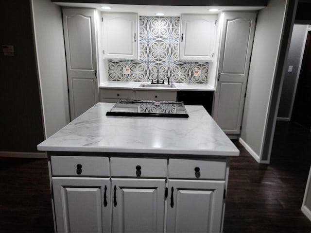 kitchen with decorative backsplash, a kitchen island, dark wood-type flooring, and sink