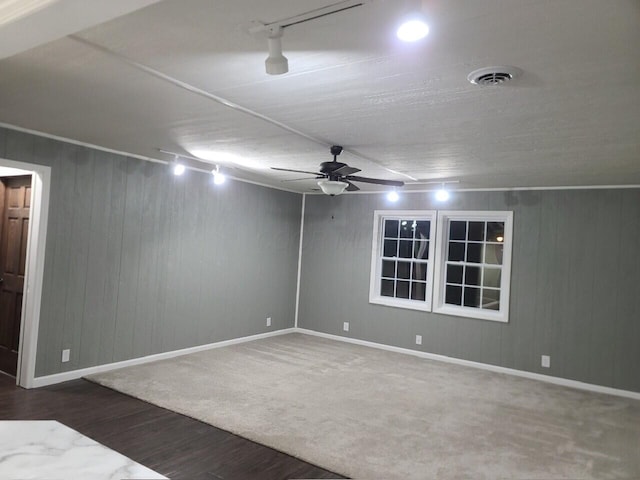 carpeted spare room featuring ceiling fan, vaulted ceiling, and track lighting