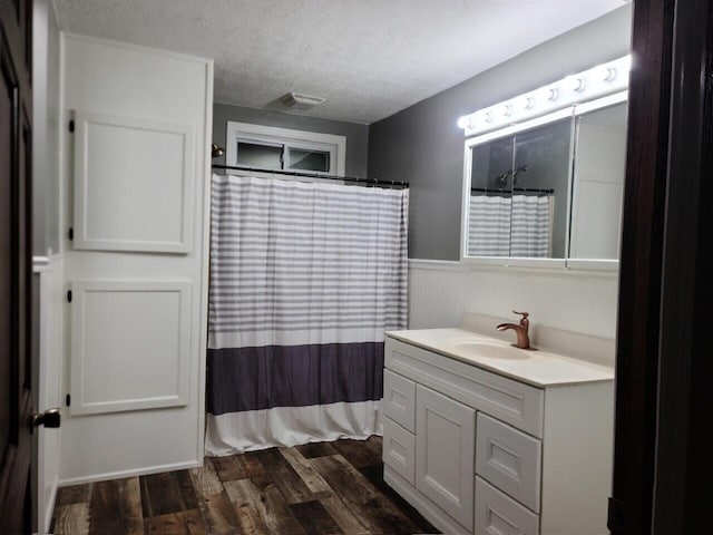 bathroom with vanity, hardwood / wood-style floors, a textured ceiling, and a shower with shower curtain