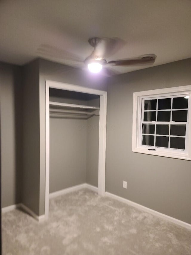 unfurnished bedroom with carpet, ceiling fan, and a closet