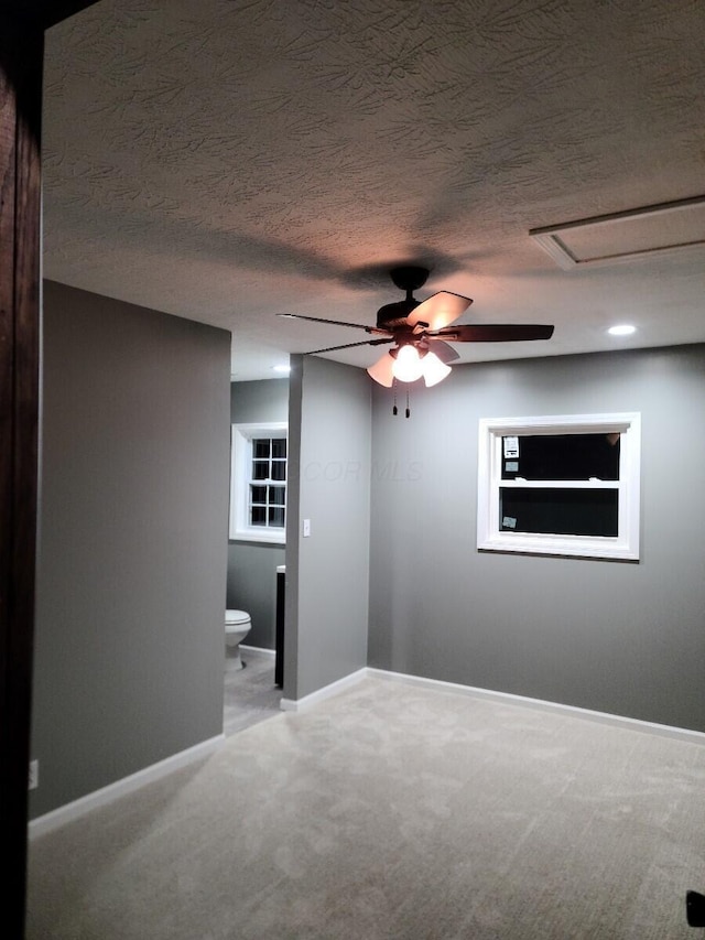 carpeted spare room with ceiling fan and a textured ceiling