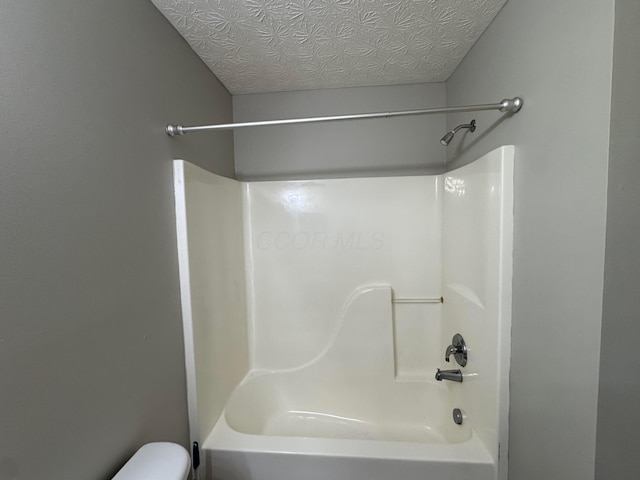 full bath with a textured ceiling, shower / bathtub combination, and toilet