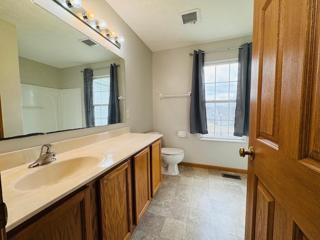 bathroom with toilet, vanity, and visible vents