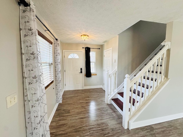 entrance foyer featuring stairway, wood finished floors, and a healthy amount of sunlight