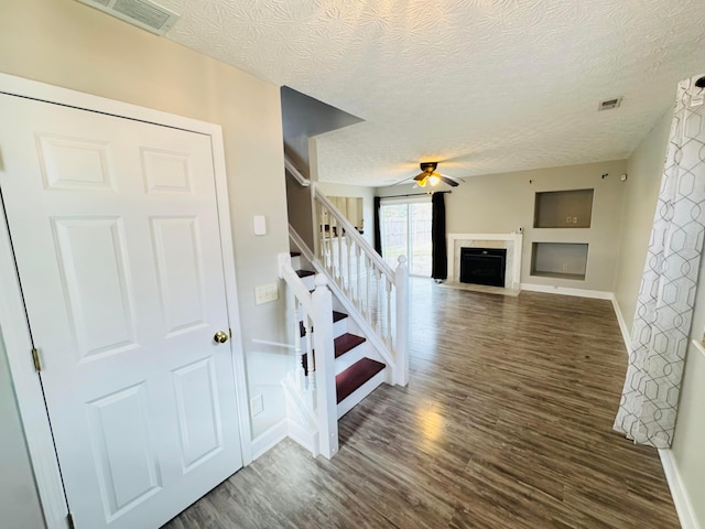 interior space featuring a fireplace with flush hearth, visible vents, and wood finished floors