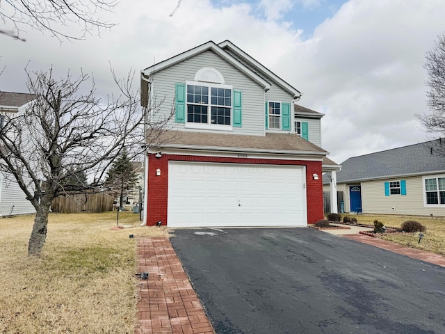 traditional-style house featuring an attached garage, a front lawn, aphalt driveway, and brick siding