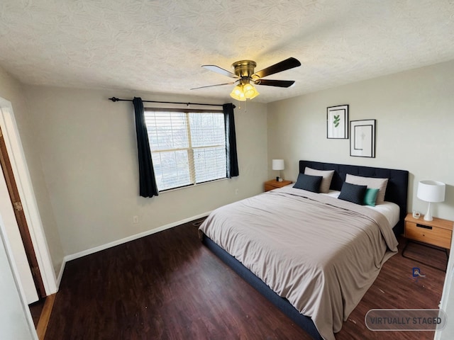 bedroom featuring a textured ceiling, baseboards, and wood finished floors