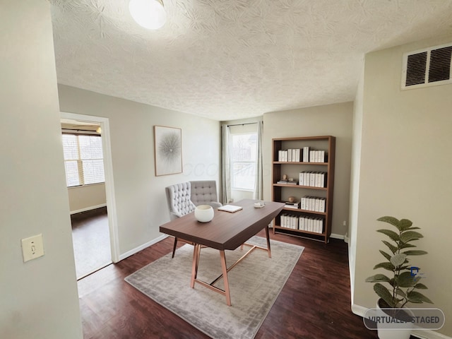 office area featuring dark wood-style floors, baseboards, visible vents, and a textured ceiling