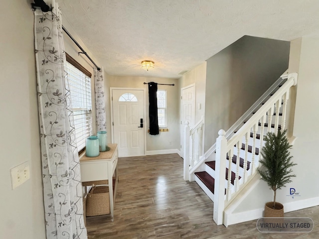 entrance foyer featuring a healthy amount of sunlight, stairs, baseboards, and wood finished floors