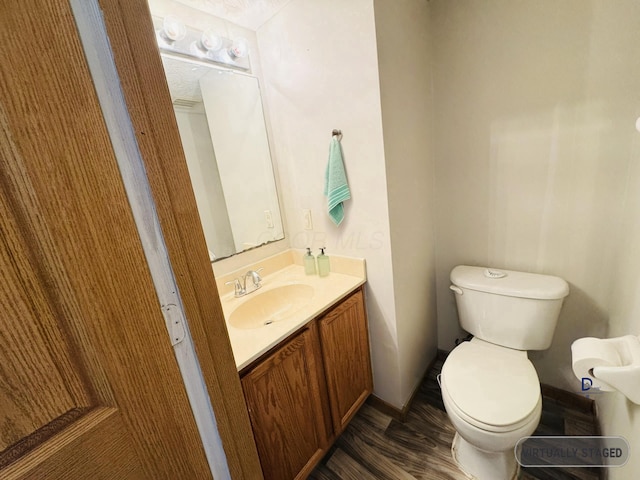 bathroom featuring wood finished floors, vanity, and toilet