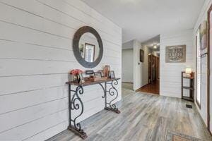 hallway featuring hardwood / wood-style floors and wood walls