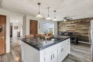 kitchen with white cabinetry, ceiling fan, pendant lighting, and dark hardwood / wood-style floors