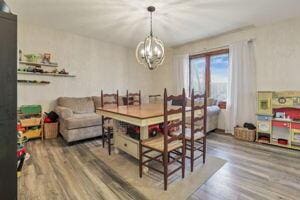 dining space featuring wood-type flooring and a notable chandelier