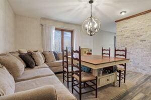 dining area with hardwood / wood-style floors and a notable chandelier