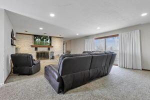 living room featuring a large fireplace and carpet floors