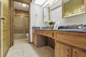 bathroom featuring tile patterned floors, vanity, a shower with shower door, and toilet