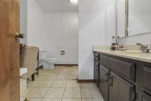 bathroom featuring toilet, vanity, and tile patterned floors