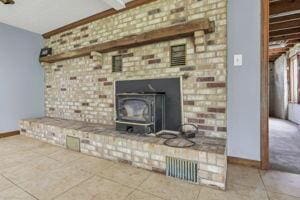 unfurnished living room with tile patterned floors and beamed ceiling