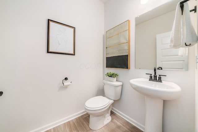 bathroom featuring wood-type flooring and toilet