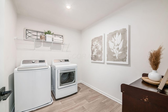 laundry area featuring light wood-type flooring and separate washer and dryer