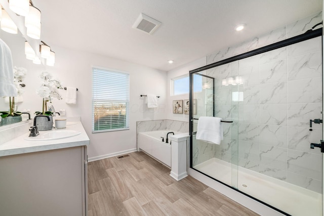 bathroom with vanity, wood-type flooring, and plus walk in shower