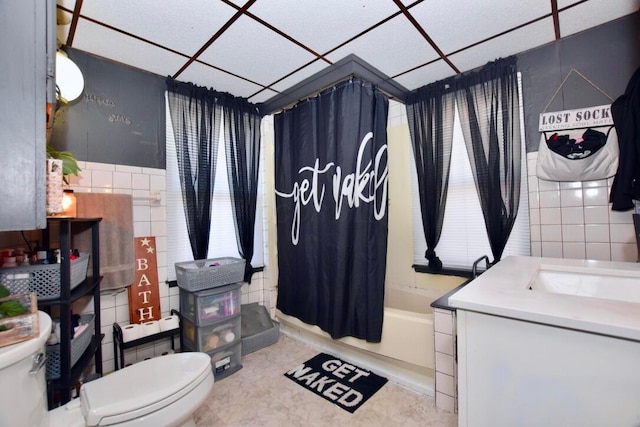 full bathroom featuring toilet, tile walls, tile patterned floors, shower / bathtub combination with curtain, and vanity