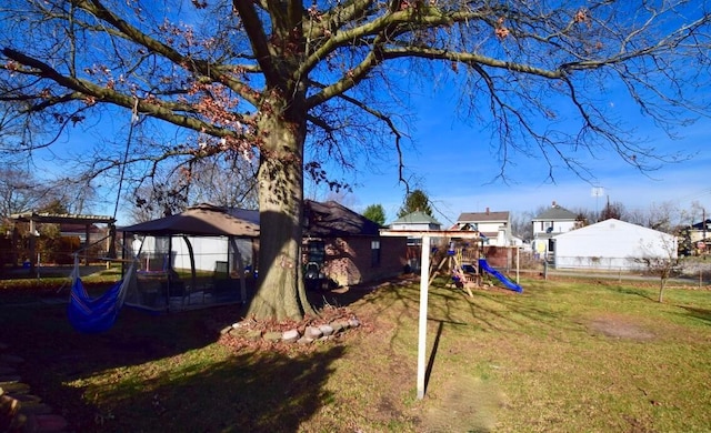 view of yard featuring a playground and a trampoline