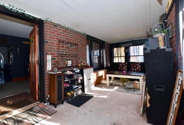 living room with brick wall and carpet flooring