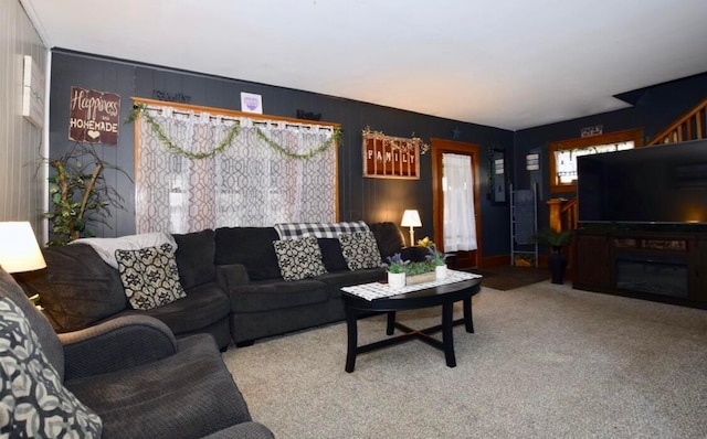 living room featuring carpet and wooden walls