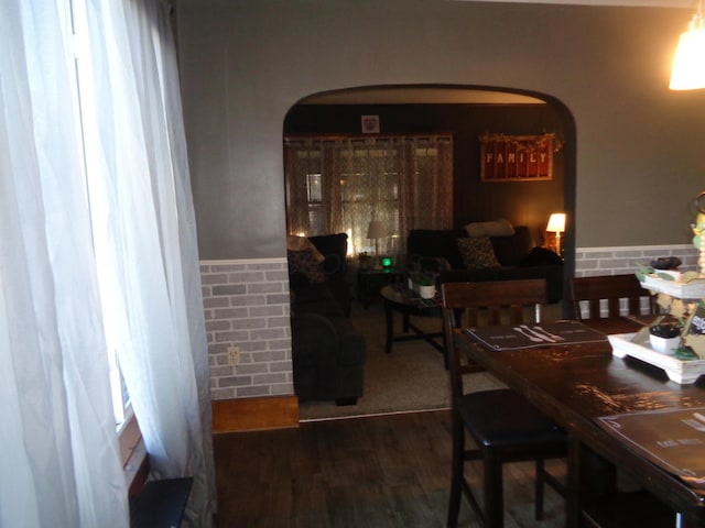 dining area featuring dark hardwood / wood-style flooring and brick wall