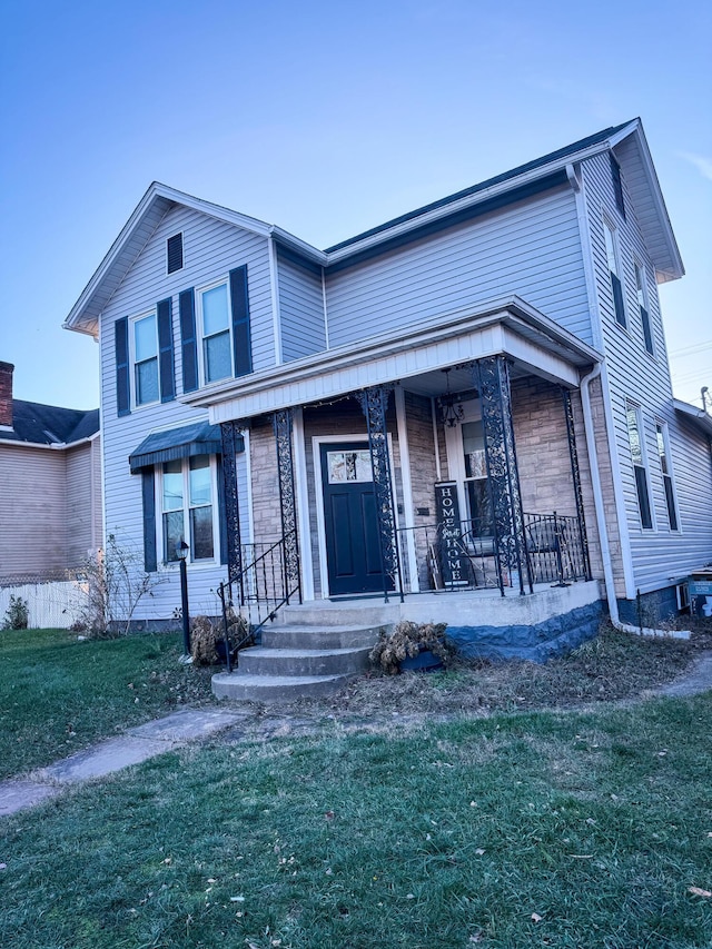 view of front of house with covered porch and a front yard