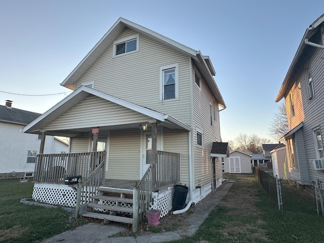 view of front facade with a shed, a front lawn, and a porch