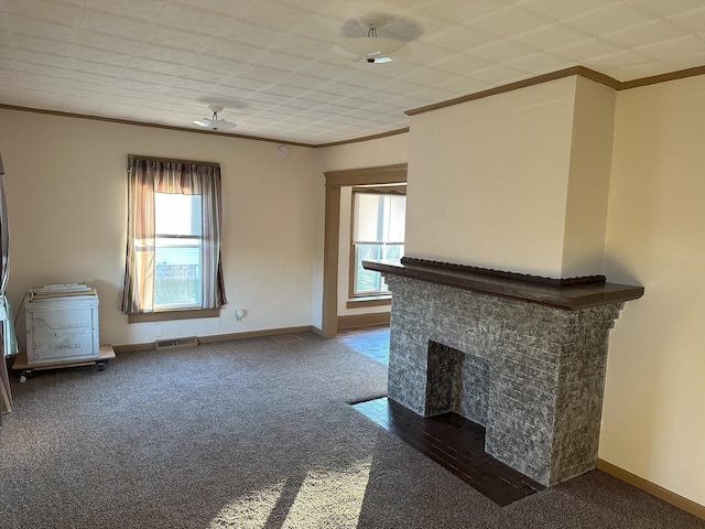 unfurnished living room featuring carpet, crown molding, ceiling fan, and a healthy amount of sunlight