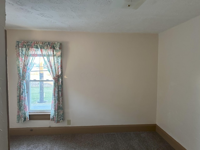 empty room with a textured ceiling and carpet floors