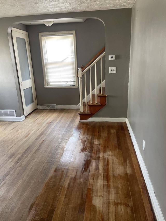 interior space featuring a textured ceiling and hardwood / wood-style flooring