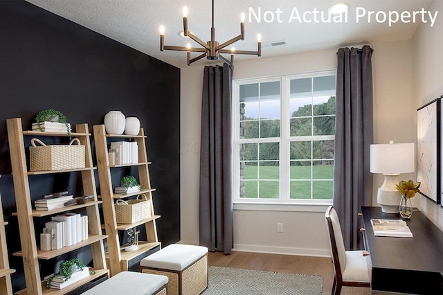 home office featuring an inviting chandelier, wood finished floors, visible vents, and baseboards