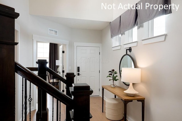 foyer with stairway, light wood-style floors, and visible vents