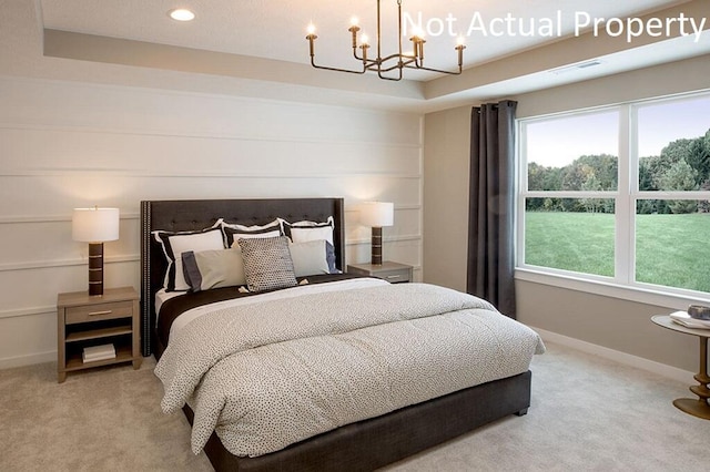 carpeted bedroom featuring a chandelier, a tray ceiling, and baseboards